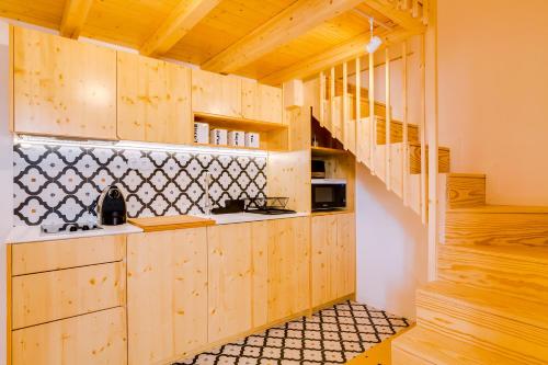a kitchen with wooden cabinets and a staircase at A Casa D'Amelie in Faro