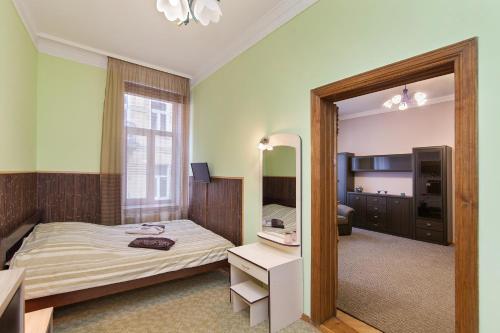 um quarto de hotel com uma cama e um espelho em Opera Theater Apartments em Lviv