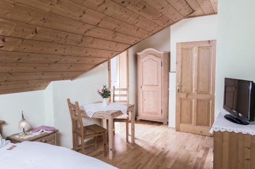a bedroom with a table and a tv and a bed at Landhof Lazarus in Mooskirchen