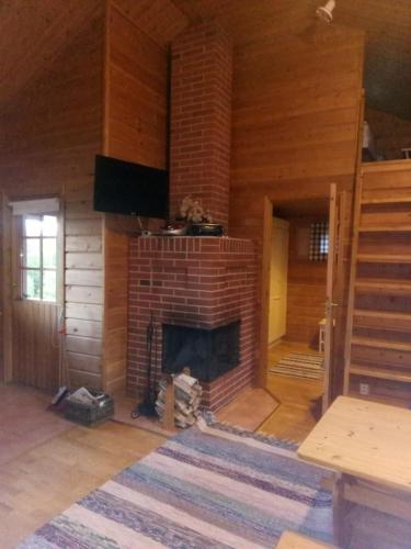 a living room with a brick fireplace in a house at Metsorinne in Kotila