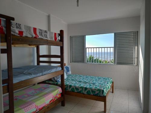 1 Schlafzimmer mit 2 Etagenbetten und einem Fenster in der Unterkunft Vista para o Mar Praia Grande in Praia Grande
