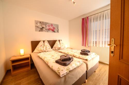 een slaapkamer met 2 bedden en handdoeken bij Appartement Gruber-Hofer in Altenmarkt im Pongau