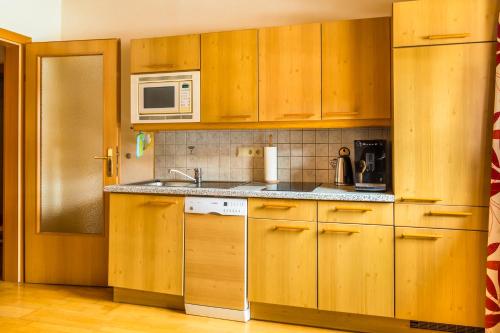 a kitchen with wooden cabinets and a microwave at Urbangut in Sankt Michael im Lungau