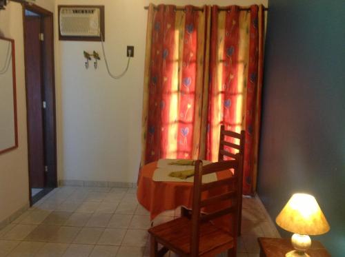 a room with a table and two chairs and a lamp at Pousada Telhado Azul in Abraão