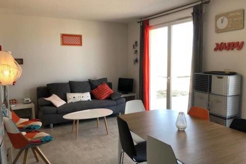 a living room with a couch and a table at Location villa 2 chambres A Lavanda piscine Bonifacio in Bonifacio