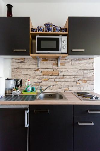 a kitchen with a sink and a microwave at Apartments an der Caracalla Therme in Baden-Baden