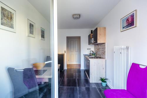 a kitchen and a living room with a red chair at Apartments an der Caracalla Therme in Baden-Baden