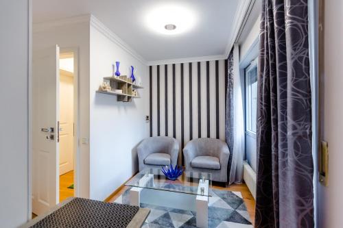 a living room with two chairs and a glass table at Apartments an der Caracalla Therme in Baden-Baden