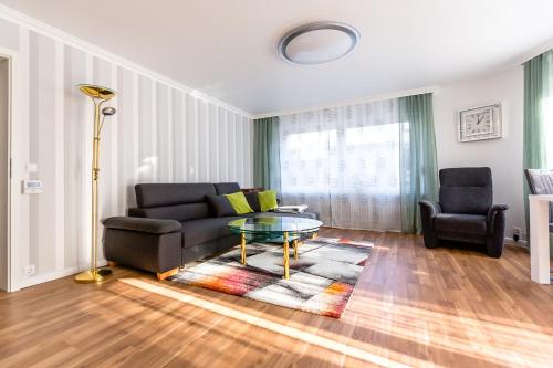 a living room with a couch and a glass table at Apartments an der Caracalla Therme in Baden-Baden