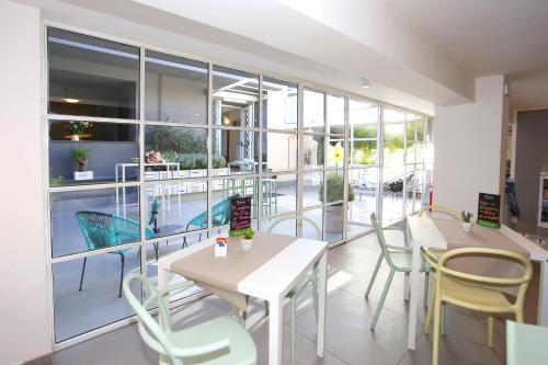 a restaurant with tables and chairs and a large window at Albergo Del Pino in Cercola