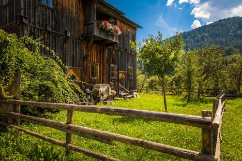 an old barn in a field next to a fence at Urbangut in Sankt Michael im Lungau