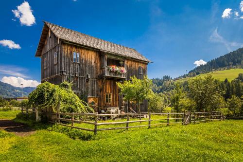 an old barn in a field with a fence at Urbangut in Sankt Michael im Lungau