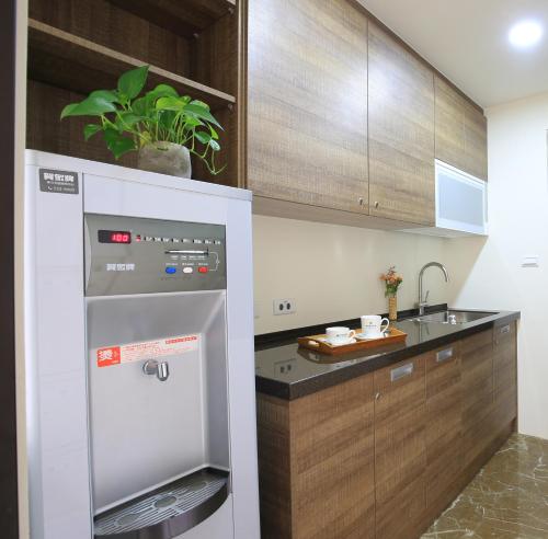 a kitchen with a stainless steel refrigerator and a sink at Darlon Hotel in Hsinchu City