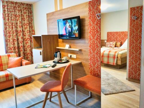 a hotel room with a table and a bed at Hotel Maurer in Saarwellingen