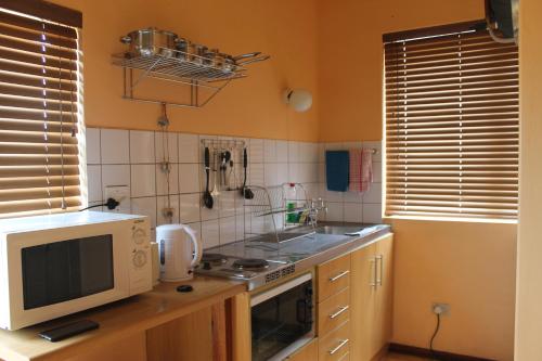 a kitchen with a microwave and a stove top oven at The Timeless Way Self Catering Accommodation in Swakopmund