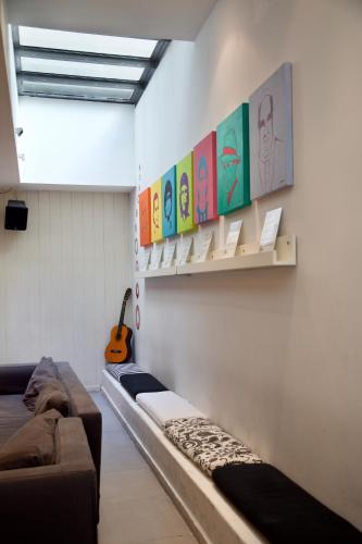 a room with a couch and a guitar on a wall at America Del Sur Hostel Buenos Aires in Buenos Aires