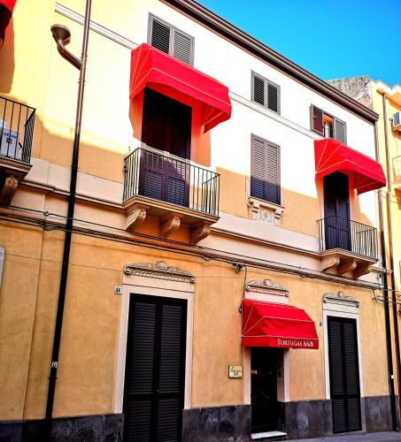 a building with red umbrellas on the side of it at Tortugas B&B in Giarre