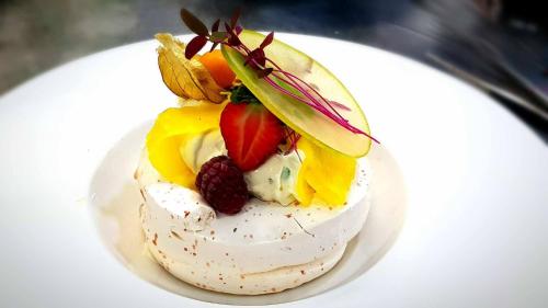 a dessert with fruit on a white plate at Nova Stodola in Kłomnice
