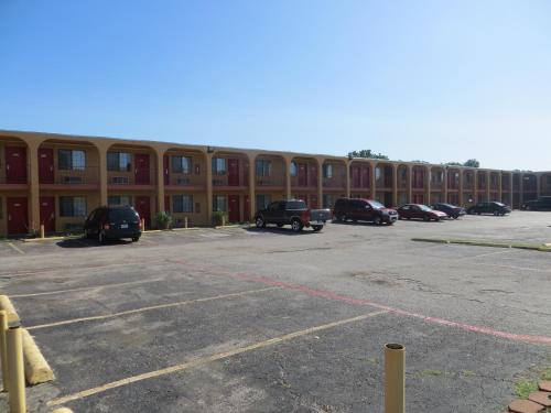 a parking lot in front of a large building at Welcome Inn in Dallas