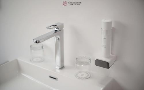 - un lavabo avec un robinet et 2 verres dans l'établissement Hotel Le Bourgogne, à Évian-les-Bains