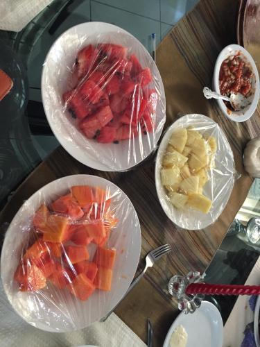 four plastic bowls of fruit on a wooden table at Apartamentos Comodos Cerca del Aeropuerto in Guatemala