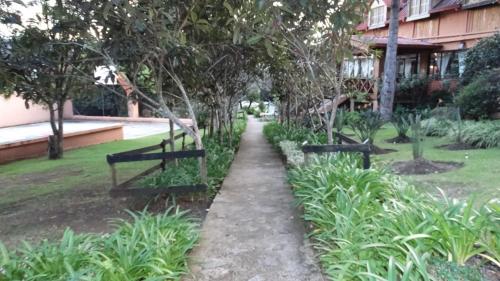 a path in a park with trees and plants at Hotel Rancho Constanza & Cabañas de la Montaña in Constanza