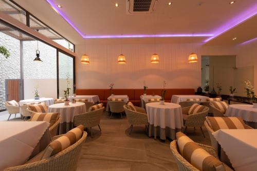 a dining room with white tables and chairs at Patong Heights in Patong Beach