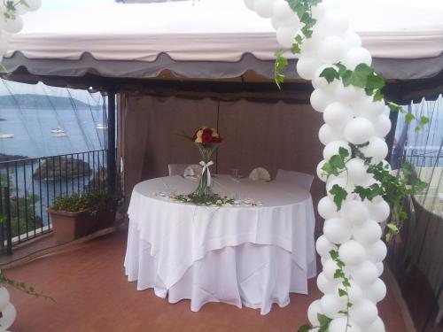 a white table with a vase of flowers on it at Hotel La Ninfea in Ischia