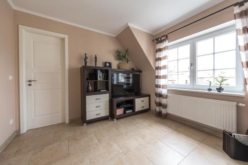a living room with a tv and a window at Ferienwohnungen Schön in Teltow