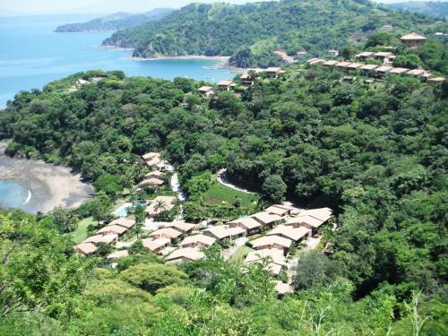 an aerial view of a village on a hill next to a beach at Bahia Pez Vela Resort in Ocotal