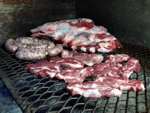 a group of meat and sausages cooking on a grill at Apartamentos Comodos Cerca del Aeropuerto in Guatemala