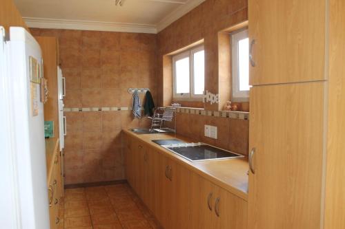 a kitchen with wooden cabinets and a sink at The Timeless Way Self Catering Accommodation in Swakopmund