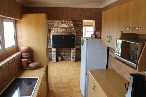 a kitchen with a white refrigerator and a tv at The Timeless Way Self Catering Accommodation in Swakopmund