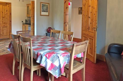 a dining room table and chairs with a checkered table cloth at Cottage 173 - Clifden in Clifden
