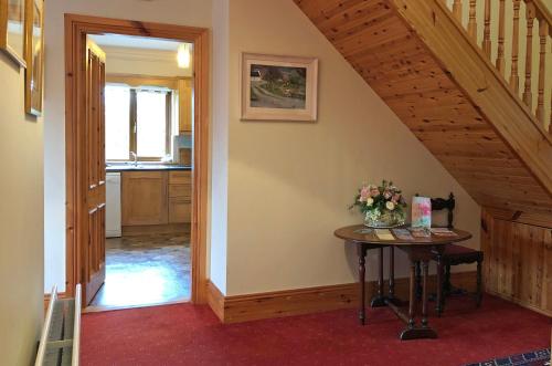 a hallway with a table and a staircase in a house at Cottage 173 - Clifden in Clifden