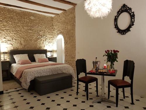 une chambre avec un lit et une table avec des chaises dans l'établissement Le Grand Coudreau, à Nazelles-Négron