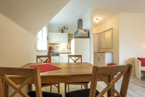 a kitchen and dining room with a wooden table and chairs at Ferienwohnungen Schön in Teltow