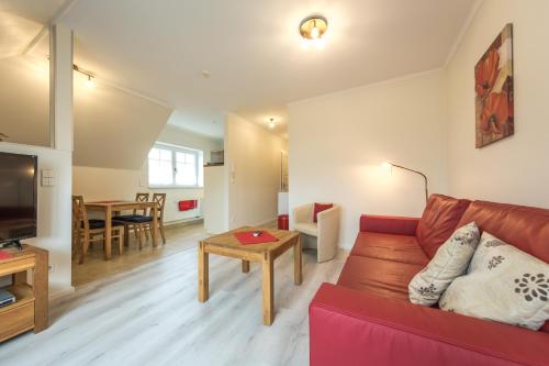 a living room with a red couch and a table at Ferienwohnungen Schön in Teltow