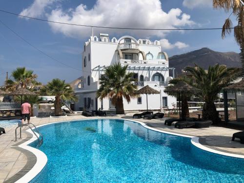 a hotel with a swimming pool in front of a building at Black Coast Santorini in Perivolos