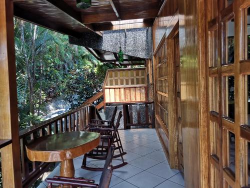 a wooden deck with a wooden table and chairs at Hotel Costa Verde in Manuel Antonio