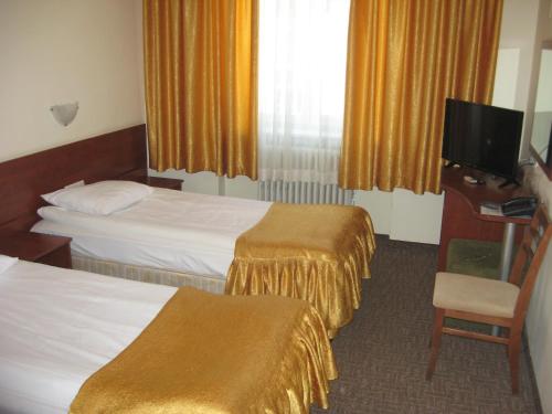 a hotel room with two beds and a television at Slavyanska Beseda Hotel in Sofia