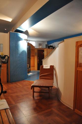a living room with a chair and a staircase at Hotel Elena in Saint Vincent