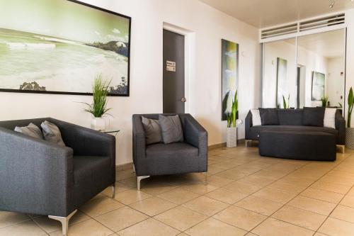 a waiting room with two chairs and a painting on the wall at Casa Verde Hotel - Steps to the Beach, Pool, Restaurant & Bar in Rincon