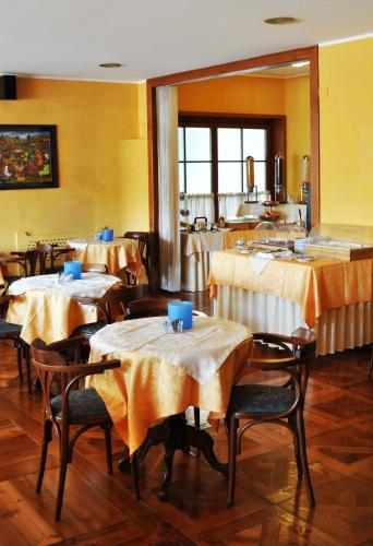 a restaurant with tables and chairs with yellow walls at Hotel Elena in Saint Vincent