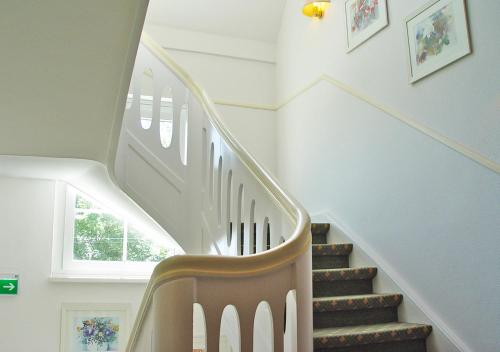 a staircase in a home with a wooden stair case at Hotel Waldhusen - Adults Only in Kücknitz