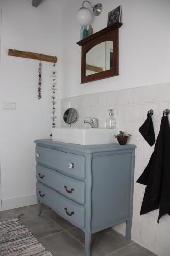 une salle de bain avec un lavabo bleu et un miroir dans l'établissement Au Coin des Cerisiers, à Montclus