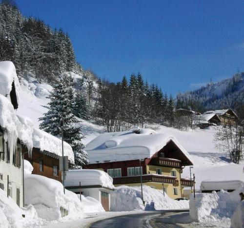 un edificio coperto di neve vicino a una strada di Haus Christian a Klösterle am Arlberg