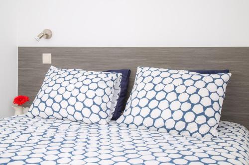 a bedroom with a bed with two pillows at Alboi Loft in Aveiro
