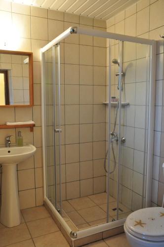 a bathroom with a shower with a sink and a toilet at Hotel Villa Monte in Cıralı