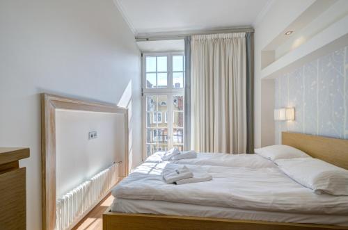 a bedroom with a large white bed with a window at Stylish Apartment in Heart of Oldtown in Gdańsk